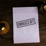 Dokument prawny z pieczęcią Innocent i sędziowskim młotkiem na biurku