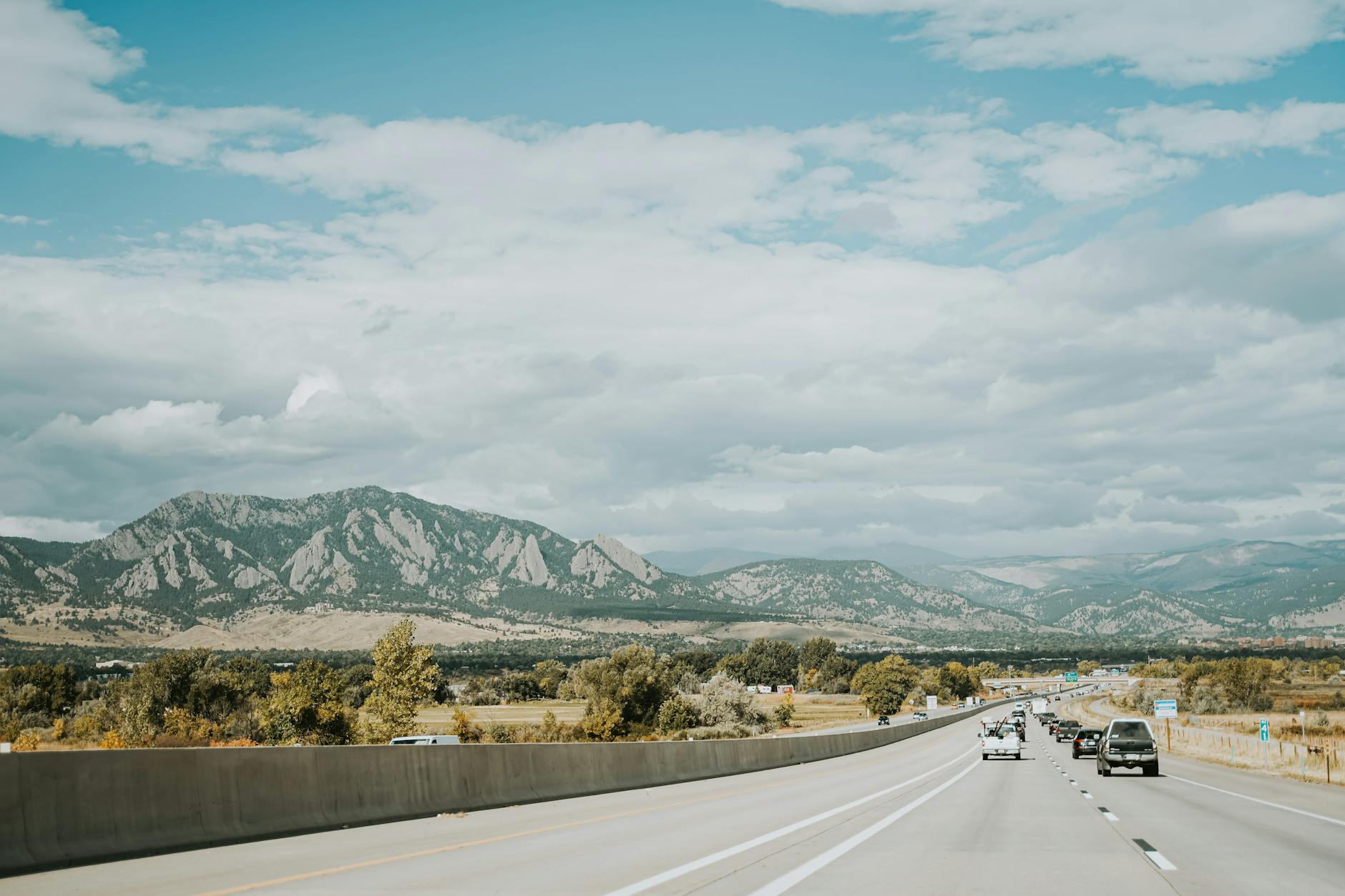 Górska szosa w słoneczny dzień z widokiem na jesienne szczyty