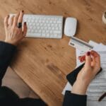 Kobieta przy biurku płaci kartą za licencje online na komputerze