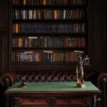 Zielony stół z młotkiem sędziowskim i figurą Temidy w bibliotece