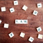 Klocki Scrabble z napisem LAW na drewnianym stole
