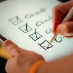 Zbliżenie na checklistę na tablecie odhaczaną rysikiem