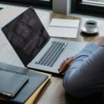 Biznesmen przy laptopie nad dokumentami i kawą