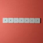 Kafelkowe litery privacy na czerwonym tle, symbol ochrony treści