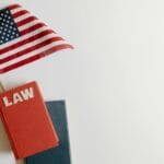 Płasko ułożona flaga USA i książka prawa symbolizujące sprawiedliwość