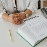 Bizneswoman przy biurku analizuje umowę, dokumenty prawne i gazetę