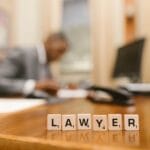 Drewniane kostki z napisem LAWYER na biurku w biurze