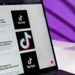 Ekran laptopa z artykułami newsowymi o TikToku na fioletowym tle