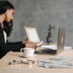 Kobieta w garsonce pracuje przy biurku z laptopem i dokumentami