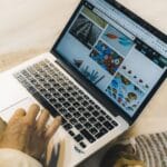 Osoba przy laptopie przeglądająca serwisy ze zdjęciami stockowymi