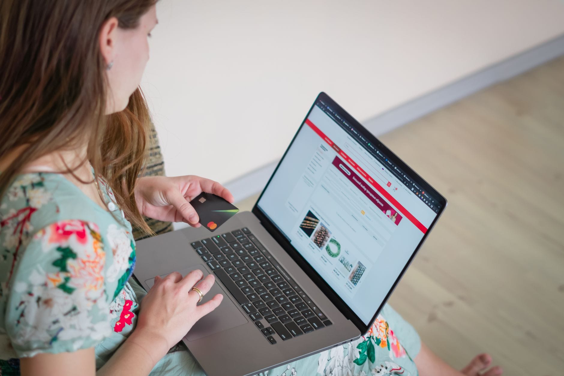 Aktualne stanowisko sądów w sprawie kopiowania opisów produktów w e‑commerce Kobieta w kwiecistej sukience robi zakupy online na laptopie z kartą